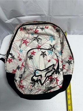 Fox Racing white polyester backpack with red, blue, and black stars and lines